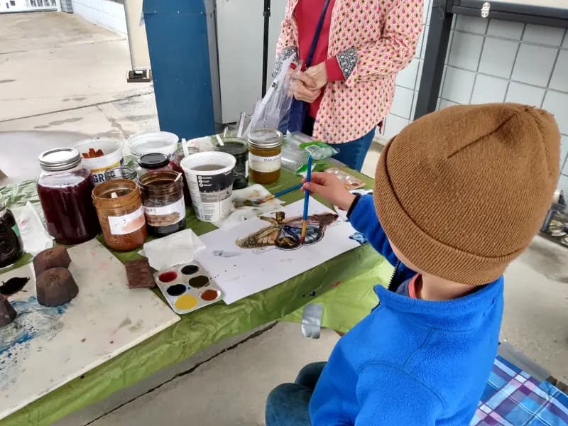 Child painting at the Earth Day community art station