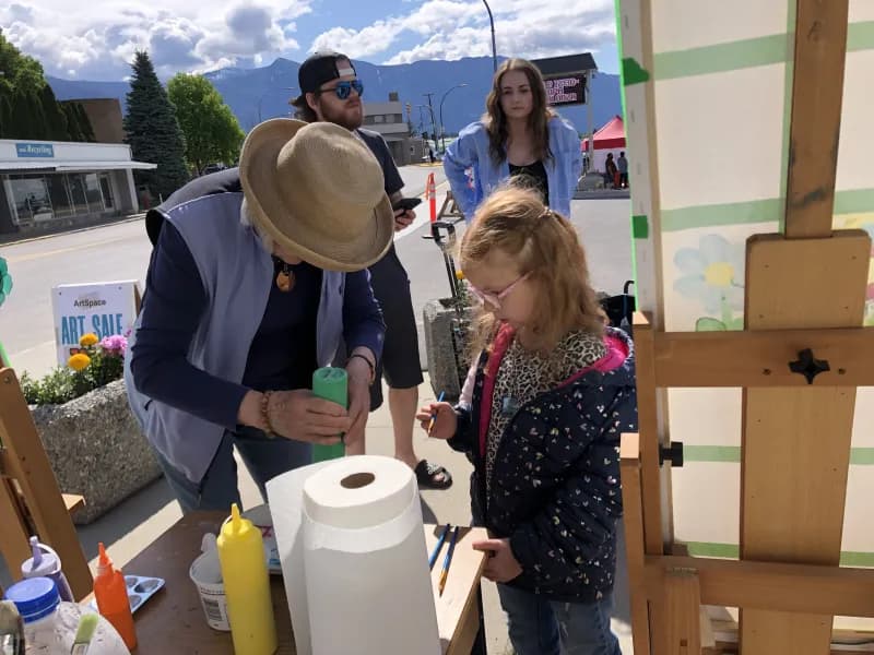 Family participating in community painting at the ArtSpace booth