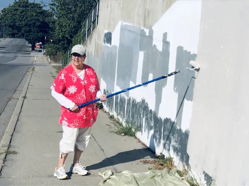 Volunteer painting the hillside wall